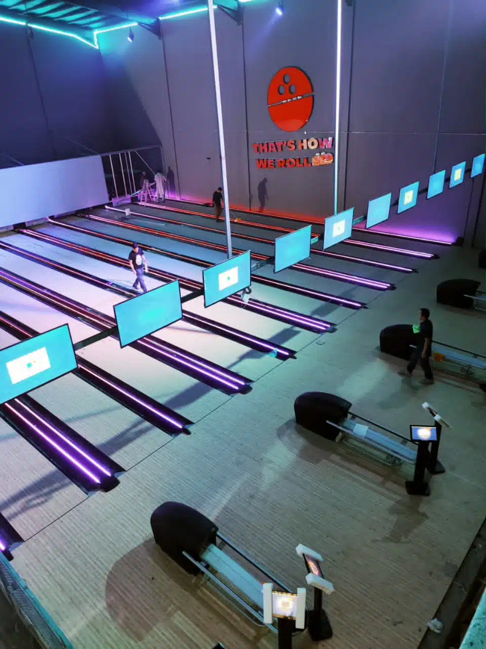  قاعة بولينج جاهزة أو قيد التشغيل جزئيًا، وتتضمن عدة مسارات مضاءة بأضواء نيون أرجوانية زاهية، وشاشات عرض كبيرة